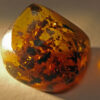 Irregularly shaped, and fiery yellow amber inclusion with several angular polished faces.