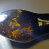 Dark and oblong shaped Myanmar amber pendant containing dense black foliage