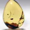 Fiery clear yellow amber pendant with visually appealing flora strands at bottom;